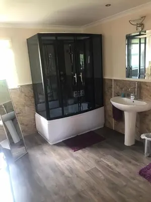 a bathroom with a large shower and a sink at Cumnock Knowes Holiday Retreat in Carsphairn