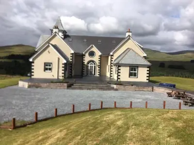 a large white house with a fence in front of it at Cumnock Knowes Holiday Retreat in Carsphairn