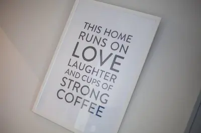 a sign that reads this home runs on love laughter and cups of strong coffee at The Warwick Apartment in Greenock