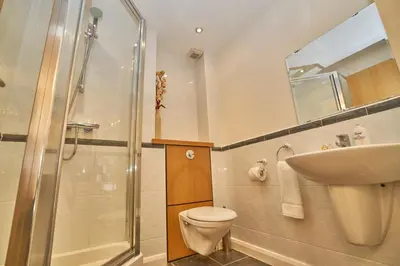 a bathroom with a toilet and a sink and a shower at Edinburgh Pearl Apartments - Fountainbridge Residence in Edinburgh