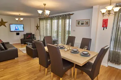 a dining room and living room with a table and chairs at Edinburgh Pearl Apartments - Fountainbridge Residence in Edinburgh