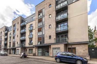 a blue car parked in front of a building at Edinburgh Pearl Apartments - Fountainbridge Residence in Edinburgh