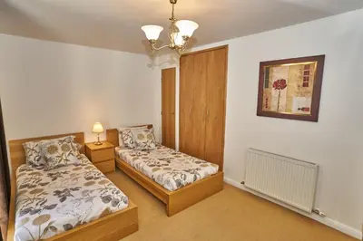 a bedroom with two beds and a picture on the wall at Edinburgh Pearl Apartments - Fountainbridge Residence in Edinburgh