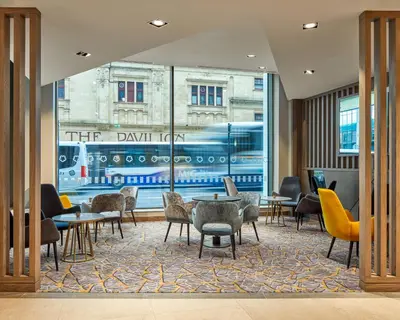 a restaurant with tables and chairs and a large window at Maldron Hotel Glasgow City in Glasgow