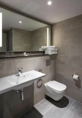 a bathroom with a sink and a toilet and a mirror at Maldron Hotel Glasgow City in Glasgow