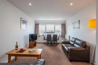 a living room with a couch and a table at Esplanade Court Holiday Apartments in Oban