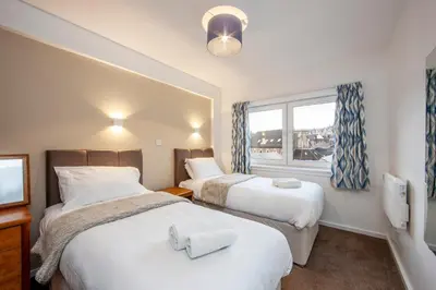 a hotel room with two beds and a window at Esplanade Court Holiday Apartments in Oban