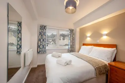 a bedroom with a bed with two towels on it at Esplanade Court Holiday Apartments in Oban