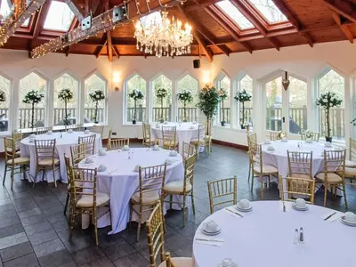 a banquet hall with tables and chairs and chandeliers at Dalgarven Spa House in Dalry
