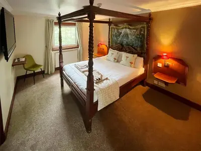 a bedroom with a four poster bed and a window at Dalgarven Spa House in Dalry