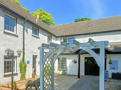 a dog standing in front of a building at Dalgarven Spa House in Dalry