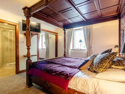 a bedroom with a canopy bed and a window at Dalgarven Spa House in Dalry
