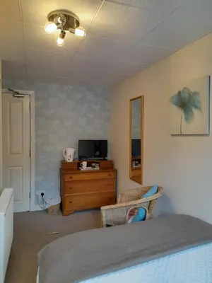 a bedroom with a bed and a dresser with a television at Elderslie Guest House in Oban