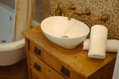 a white bowl sink on a wooden counter in a bathroom at Oakshaw Apartment in Paisley