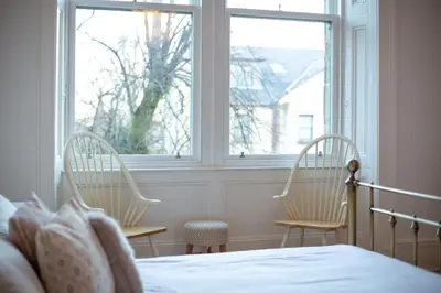 two chairs in front of a window in a bedroom at Oakshaw Apartment in Paisley
