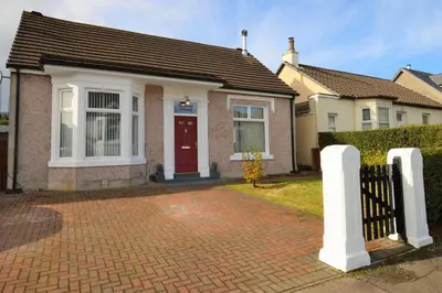 a house with a red door and a brick driveway at Freeland Cottage in Dunoon