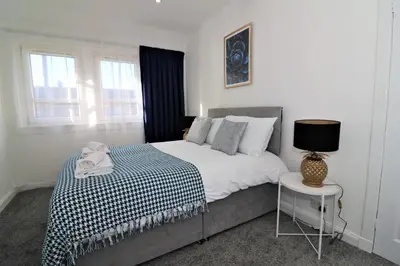 a bedroom with a bed and a table with a lamp at Jess View in Renfrew