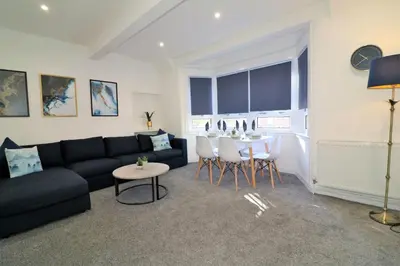 a living room with a black couch and a table at Jess View in Renfrew