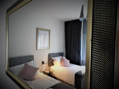 a hotel room with two beds and a mirror at Penilee Upper Apartment in Glasgow