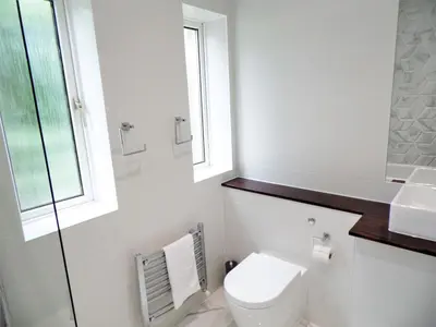 a bathroom with a toilet and a sink and a window at Penilee Upper Apartment in Glasgow