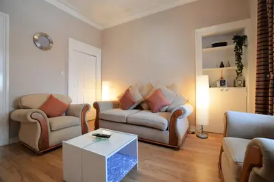 a living room with two chairs and a couch and a table at Keek Oot at 73 in Gourock