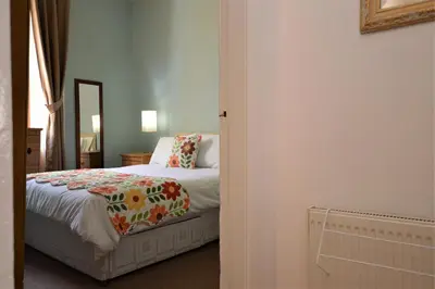 a bedroom with a bed and a mirror at Keek Oot at 73 in Gourock