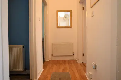 a hallway with blue walls and a mirror on the wall at Keek Oot at 73 in Gourock