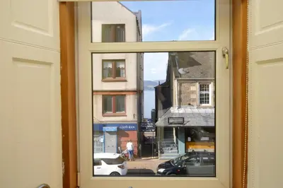 a window with a view of a street and buildings at Keek Oot at 73 in Gourock