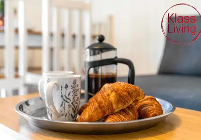 a plate of croissants and a cup of coffee on a table at Nicol Apartment by Klass Living Airdrie in Airdrie