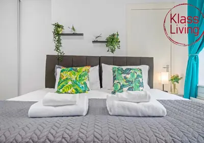 a bedroom with a large bed with two pillows at Nicol Apartment by Klass Living Airdrie in Airdrie