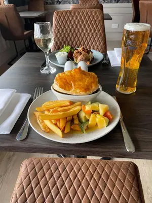 a table with two plates of food and a glass of beer at The Inn At Charlestown in Dunfermline