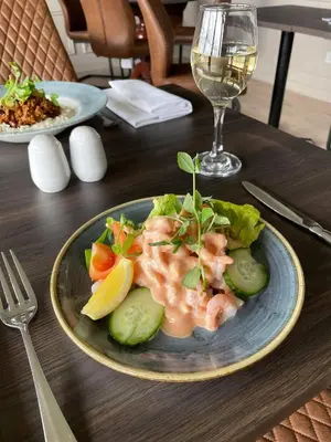 a plate of food on a table with a glass of wine at The Inn At Charlestown in Dunfermline