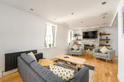 a living room with a couch and a table at Queensferry Street Lane - Fantastic 2 BR City Centre Mews House with free secure parking! in Edinburgh