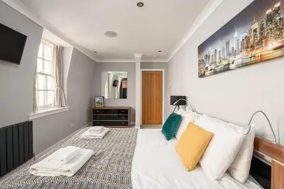 a bedroom with a bed with two towels on it at Queensferry Street Lane - Fantastic 2 BR City Centre Mews House with free secure parking! in Edinburgh