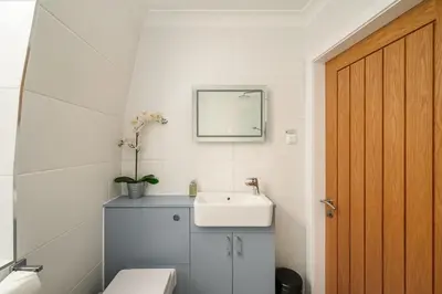 a bathroom with a sink and a toilet and a mirror at Queensferry Street Lane - Fantastic 2 BR City Centre Mews House with free secure parking! in Edinburgh