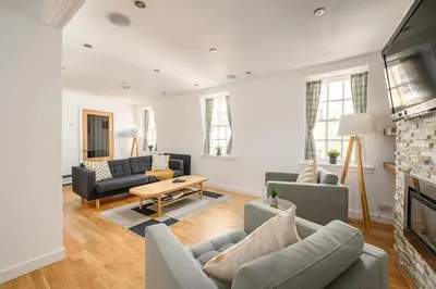 a living room with couches and a fireplace at Queensferry Street Lane - Fantastic 2 BR City Centre Mews House with free secure parking! in Edinburgh