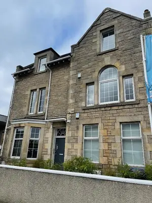 a brick house with windows and a blue sky at Premier Apartment D in Broxburn