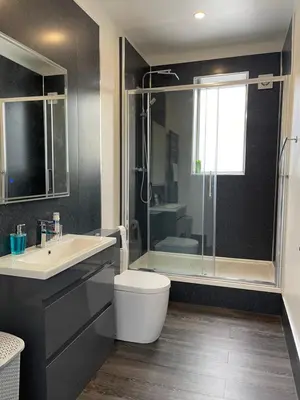 a bathroom with a toilet and a sink and a shower at Premier Apartment D in Broxburn