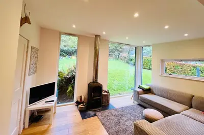 a living room with a couch and a fireplace at 4 Balvaig Cottage, Strathyre in Stirling