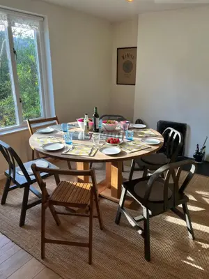 a dining room table with chairs and a table with food on it at 4 Balvaig Cottage, Strathyre in Stirling