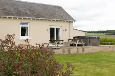 a backyard with a picnic table and a grill at Bachilton Farm Holidays in Perth