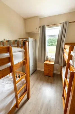 a room with three bunk beds and a window at Bachilton Farm Holidays in Perth