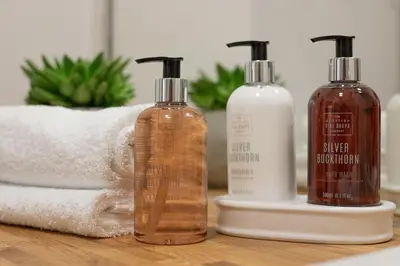 three bottles of soap and a towel on a bathroom counter at 16 1 Eildon Street in Edinburgh
