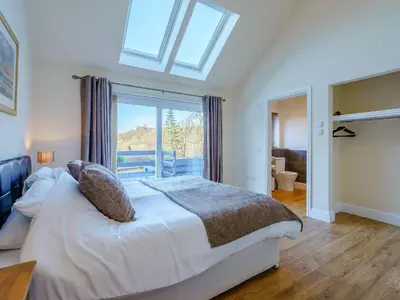 a bedroom with a bed and a large window at Invernahyle Cottage in Acharra