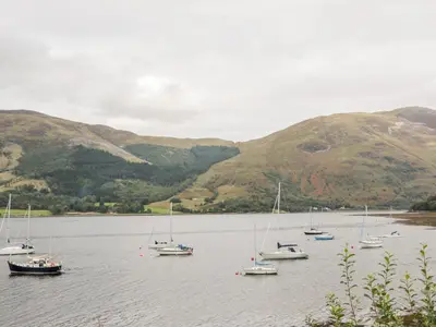 a group of boats sitting in a body of water at Sea Otter Cottage in Appin