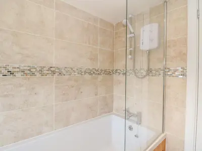 a bathroom with a shower with a bath tub at Sea Otter Cottage in Appin