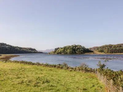 a view of a river with trees in the distance at The River Lodge in Oban
