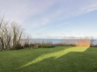 a large green field with the ocean in the background at Brewhouse Flat - Culzean Castle in Maybole