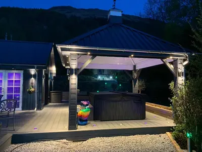 a gazebo with a statue under it at night at Little Fox Lodge Luxury Hideaway with Hot Tub Glencoe Near Fortwilliam in Glencoe