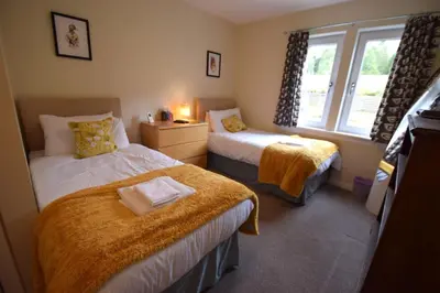 a bedroom with two beds and a window at Ben Arthur Place 6 - Sleep 6 in Lochgoilhead